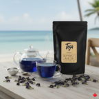 Tea packaging with a cup of tea and butterfly pea flowers on a table by a window with a view of water.