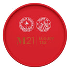 Red lid of M21 Luxury Tea packaging with sustainability logos on a white background