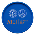 Blue container lid with M21 Luxury Tea branding and sustainability claims on a white background