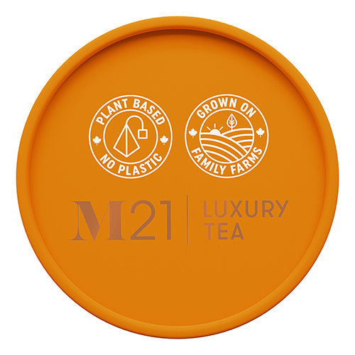 Orange lid with M21 Luxury Tea branding and sustainability claims on a white background
