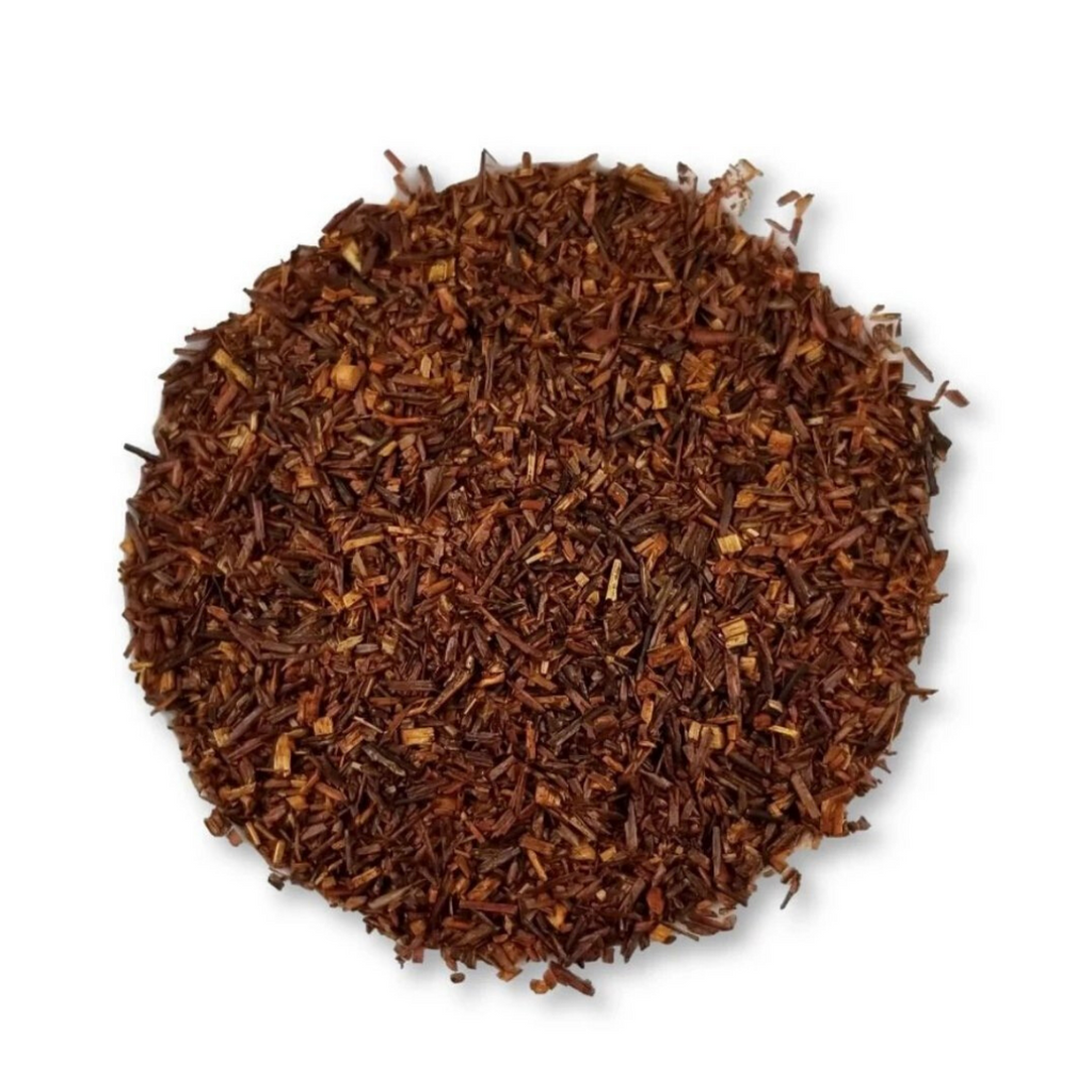 Round pile of brown rooibos tea leaves on a white background