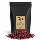 Black package of Tega Organic Hibiscus Petals with dried petals in front on a white background