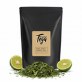Black tea packaging with 'Tega' brand label, green tea leaves, and limes on a white background