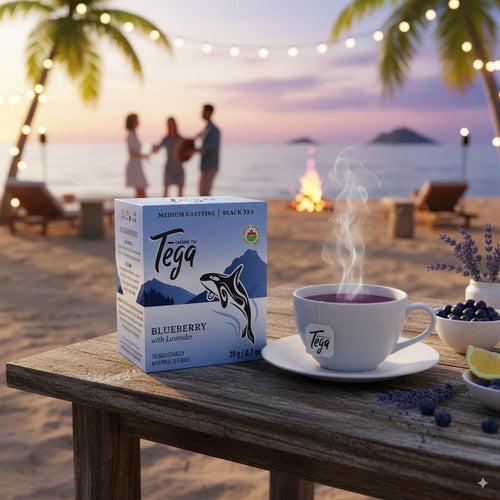 Tega tea packaging and cup on a beach table with a sunset background