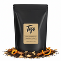 Black tea package with 'Tega' branding surrounded by cinnamon sticks and orange slices on a white background