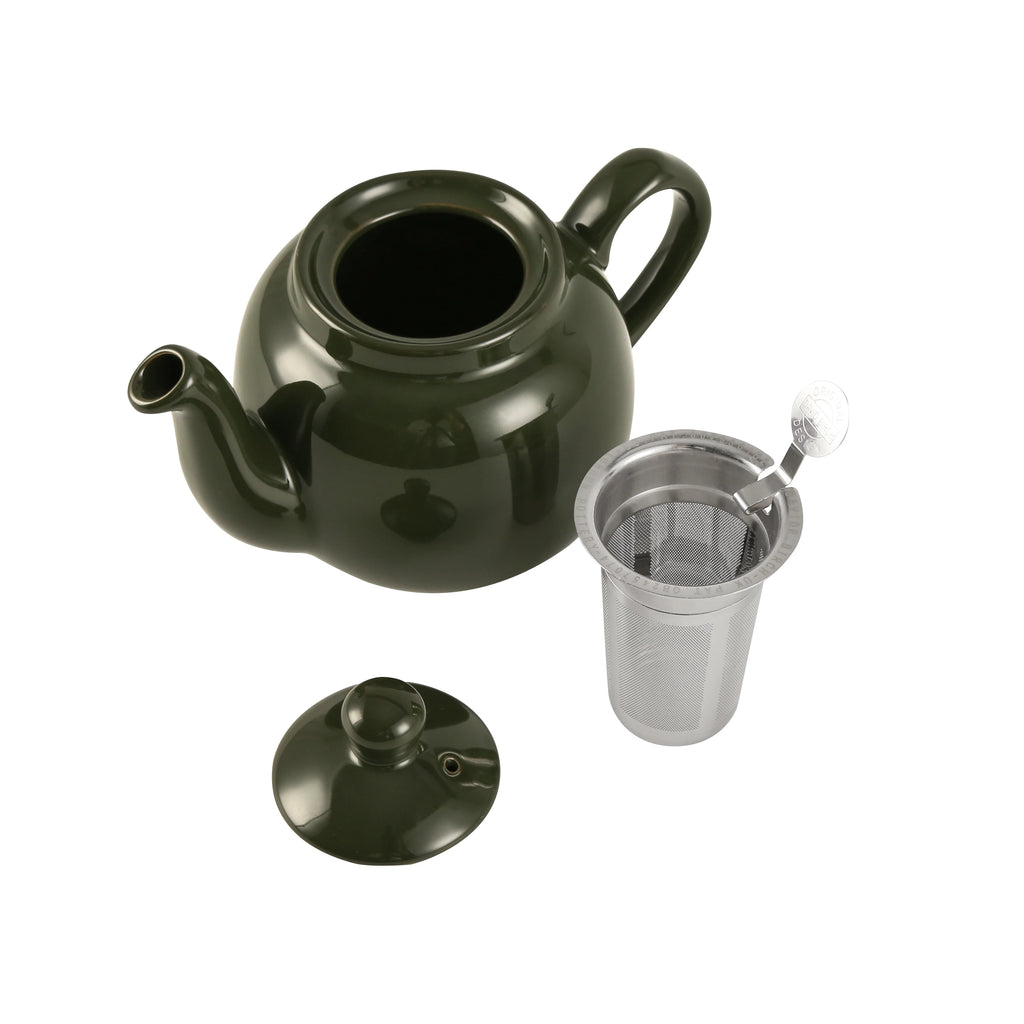 Green ceramic teapot with a metal filter on a white background