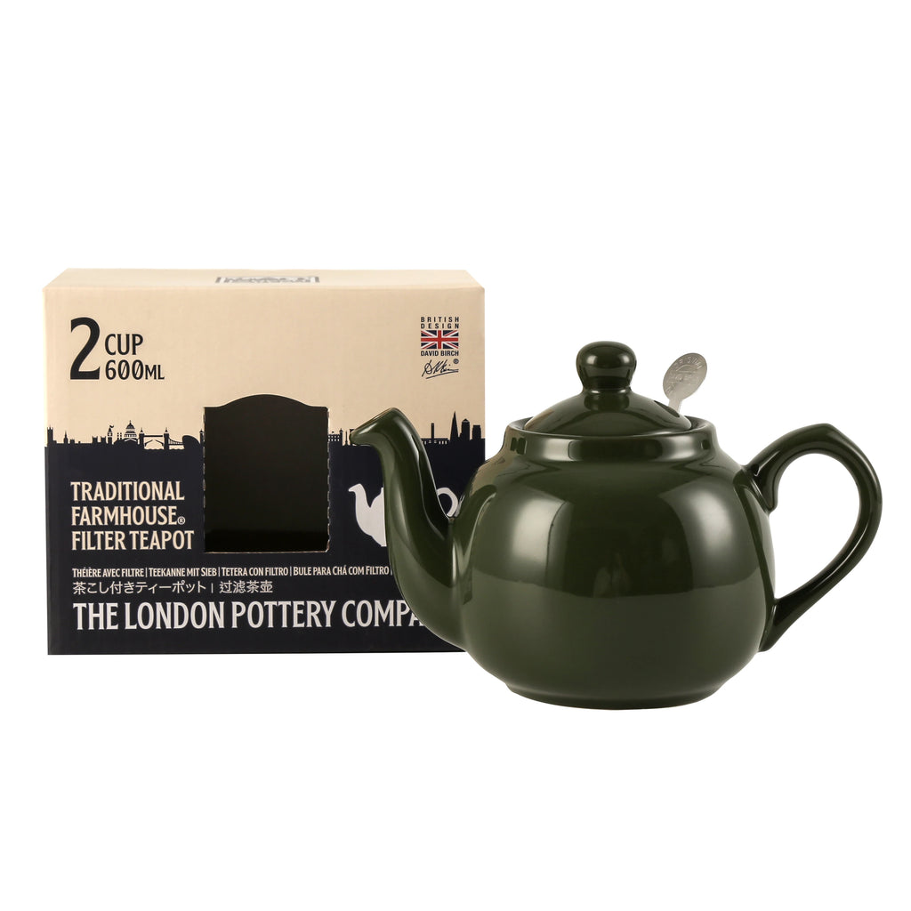 Green teapot with a box labeled 'Traditional Farmhouse Filter Teapot' on a white background